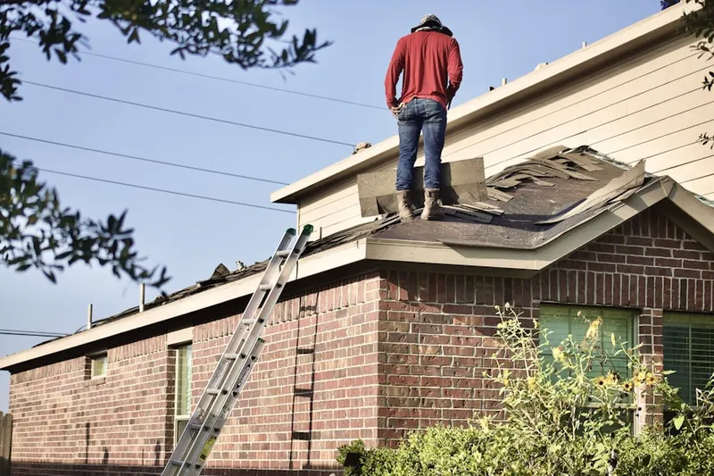 Professional roofer working on a residential roof in Hingham